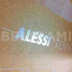 ALESSI – Particolare sul logo in rilievo argento realizzato con stampa diretta UV-LED per confezionamento linea “Progiotti” in scatole avana fustellate e assemblate.